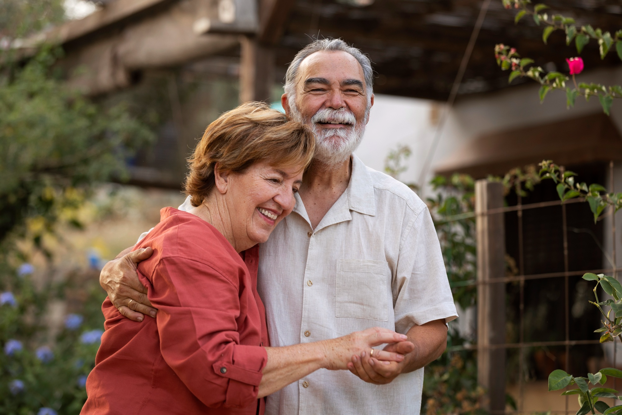 Senior couple embracing outdoors with a garden background